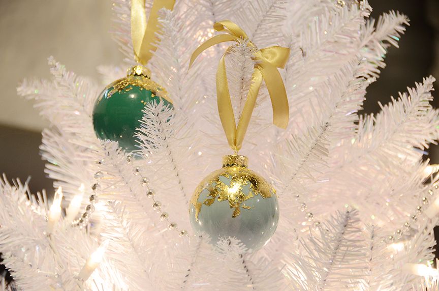 Gold leaf holiday ornaments hanging on tree