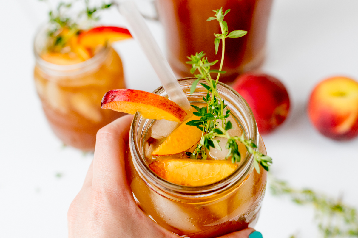 Sweet and refreshing peach and thyme iced tea - the perfect drink to cool you down on a hot day!