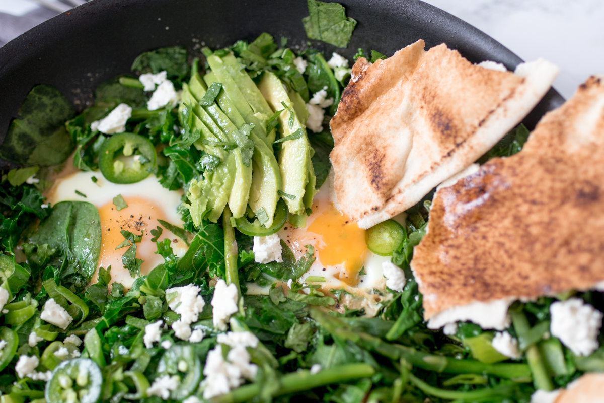 Green Shakshuka - a spicy brunch dish with dippy eggs, green veg and Thai-inspired sauce.