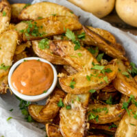 Cropped garlic parmesan potato wedges with special sauce finished tall jpg