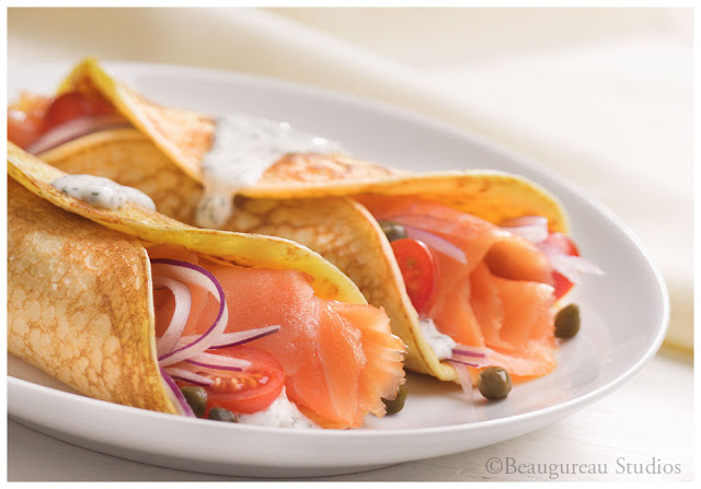 Fresh salmon cut and rolled into crepes, served with cherry tomatoes and onion 