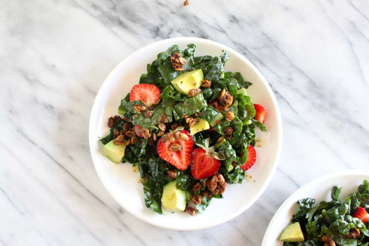 Strawberry avocado kale salad with savory granola granola and serve