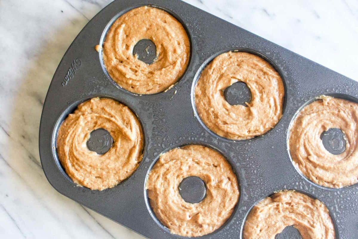 Baked pumpkin donuts with chai spice glaze spoon the batter