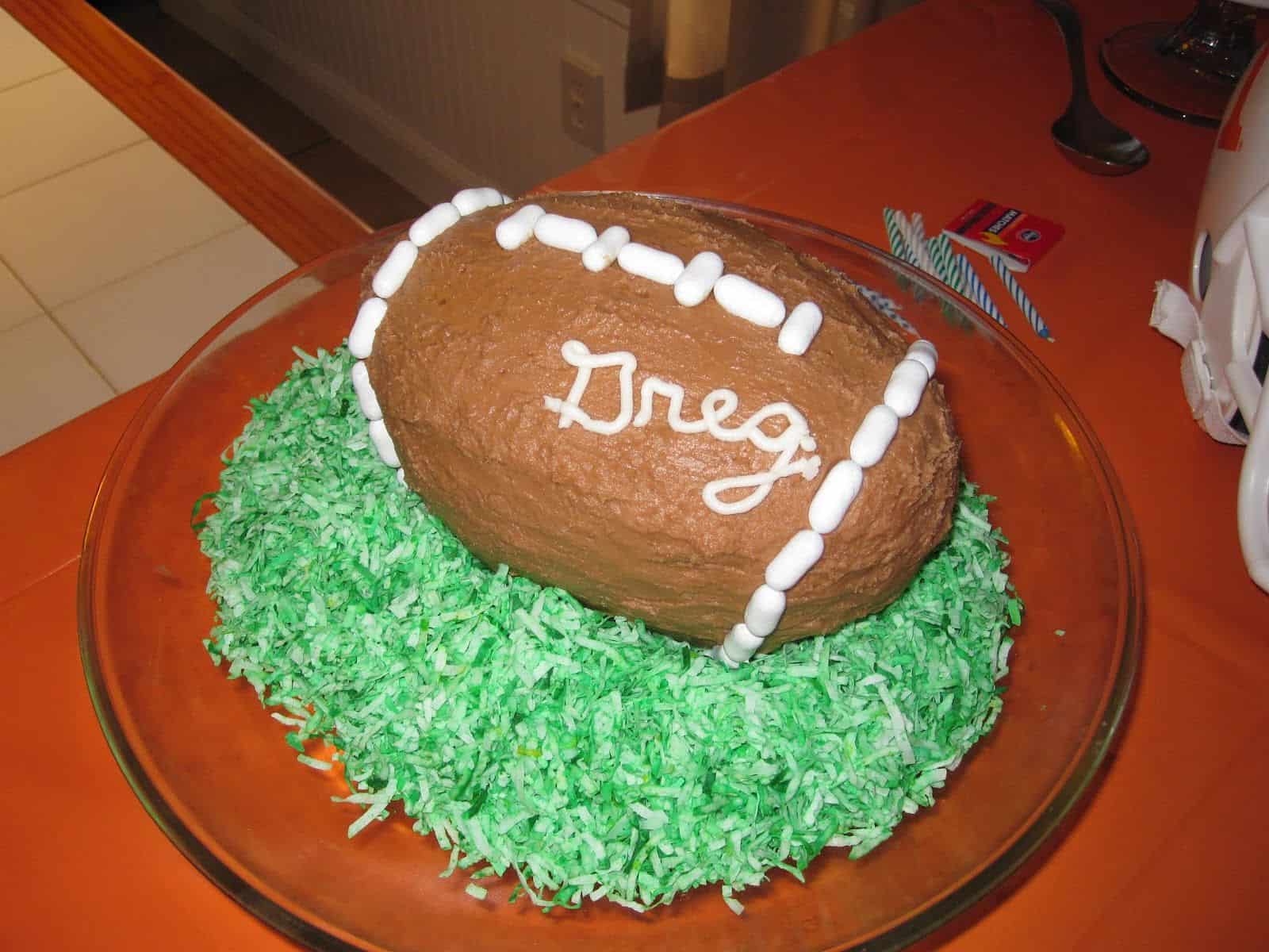 Football cake on dyed shredded coconut grass