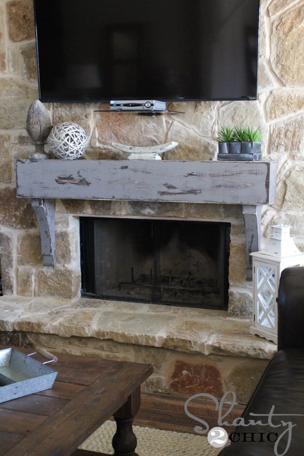Low hanging rustic mounted mantel shelf on a stone fireplace