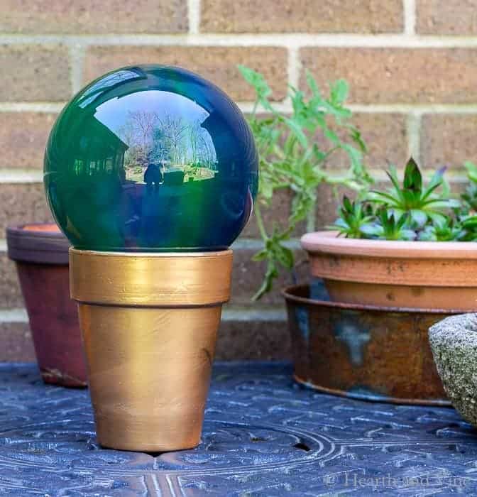 Painted terra cotta planter and plastic gazing ball