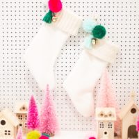 Lined christmas stocking with a knit cuff and trinket with pom poms and bells