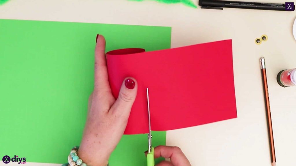 Toilet paper roll grinch cutting red paper