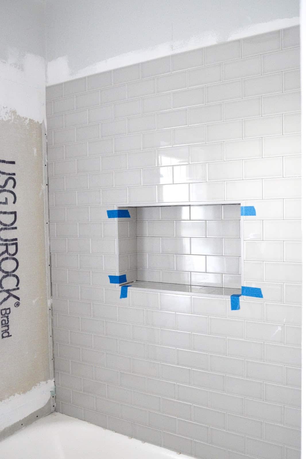 Subway tiling a wall with a shower niche