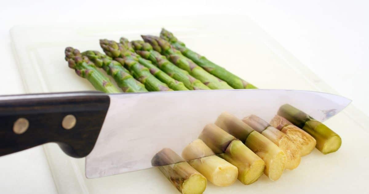 The bottom of the asparagus being cut