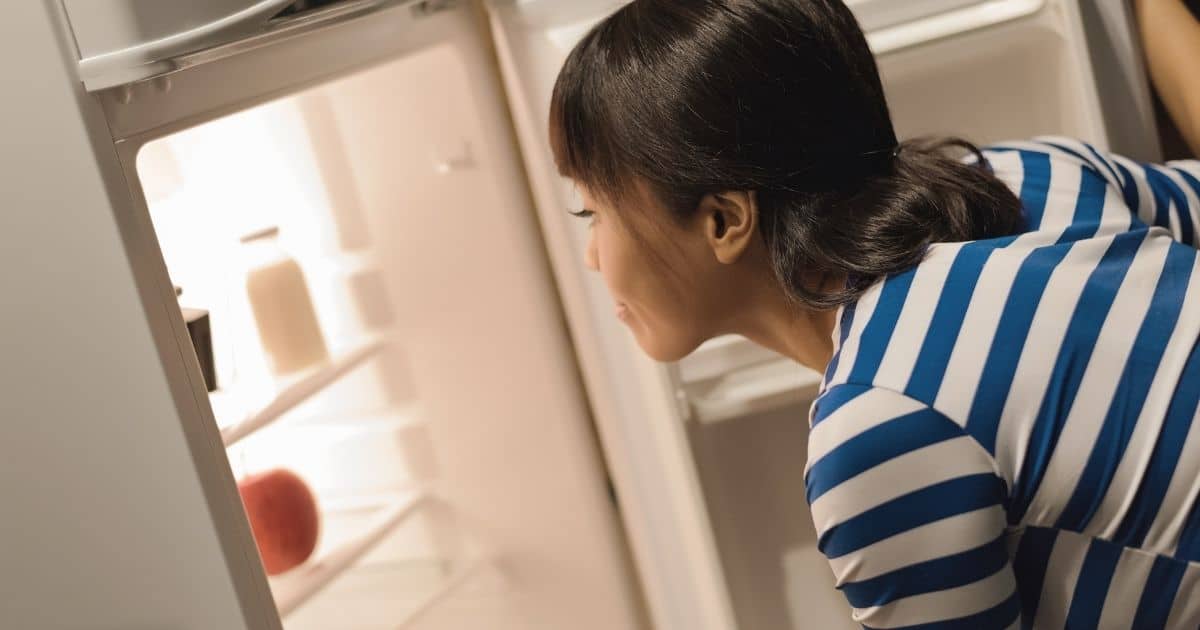 Woman putting her chocolate easter egg in her fridge