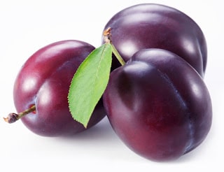 Plums with leaves on white background.