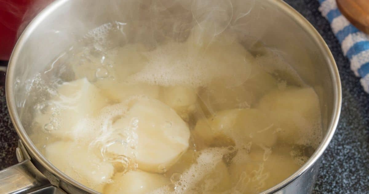 Peeled potatoes in boiling water