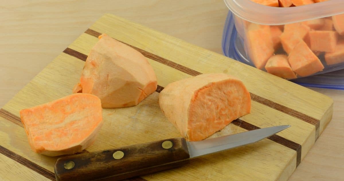 Peeled sweet potatoes being cut into cubes